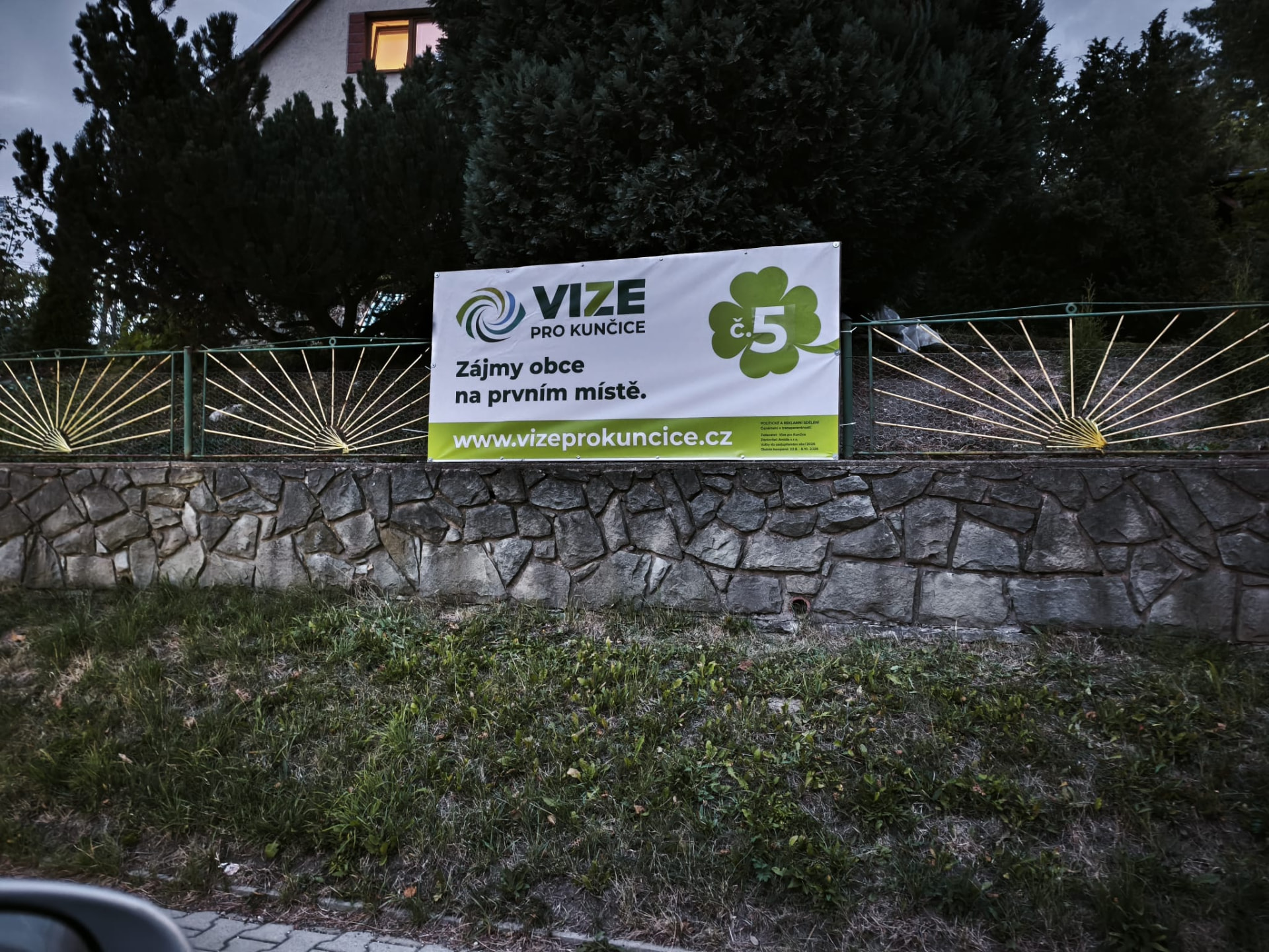 Billboard Vize pro Kunčice — Zájmy obce na prvním místě, v terénu u zdi.